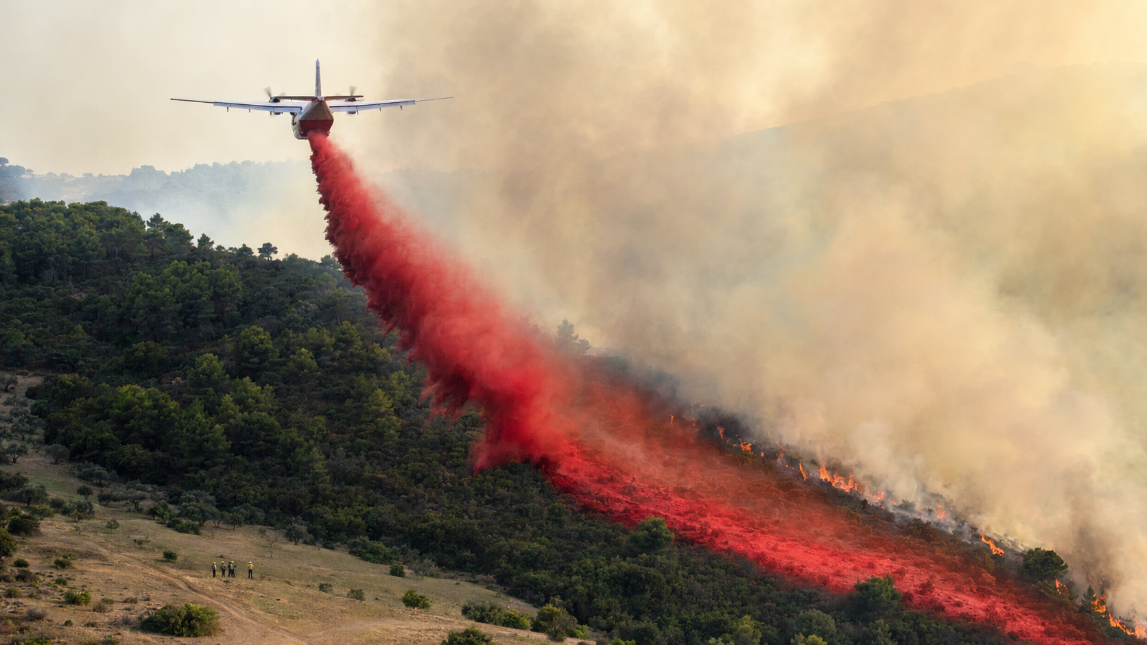 Avión cisterna realizando una descarga sobre un incendio forestal